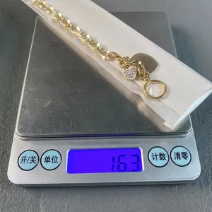 Close-up view of a gold-colored heart charm bracelet on a digital scale showing 16.3g