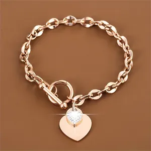 Detailed close-up of rose gold stainless steel bracelet with heart charm and OT clasp