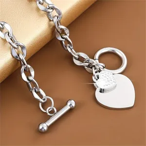 Detailed close-up view of silver stainless steel heart charm bracelet with OT toggle clasp