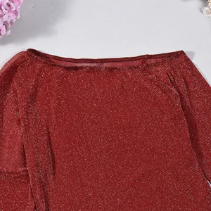 Détail en gros plan d'un haut en maille pailletée rouge avec un col bateau chic.