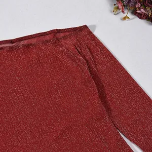 Détail d'un haut en maille rouge brillant avec décolleté bateau et manches longues.