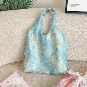 Detailed macro view of light blue floral lace tote bag with delicate sheer textured fabric