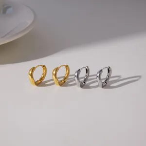 Close-up view of minimalist polished titanium steel hoop earrings in gold and silver