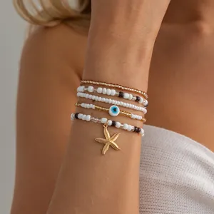 A detailed close-up shot of a beaded bracelet stack featuring starfish and evil eye charms