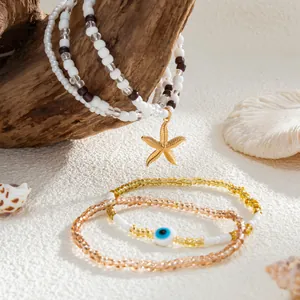 Close-up of ocean-style beaded bracelets with golden starfish and evil eye charms.