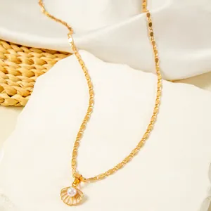 Close-up of a vintage gold-tone necklace featuring a delicate shell pearl pendant