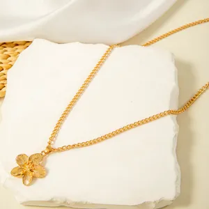Close-up view of a vintage gold flower pendant necklace on a decorative stone base