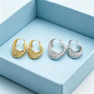 Détail macro de boucles d'oreilles tressées en forme de U en acier doré et argenté