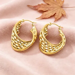 Vue détaillée des boucles d'oreilles en acier inoxydable doré avec motif torsadé