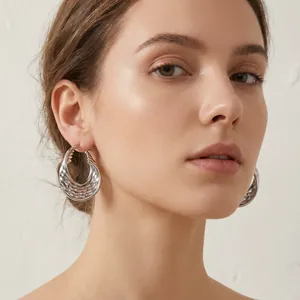 Vue détaillée des boucles d'oreilles créoles en acier inoxydable argenté texturé