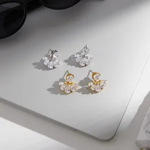 Detailaufnahme von fächerförmigen Ohrsteckern mit Zirkonia auf einem Silber-Laptop.