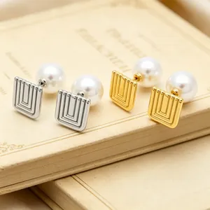 Detail shot of geometric square stainless steel earrings with elegant white pearls