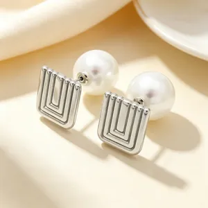 Detail shot of stainless steel geometric square earrings with large white pearls