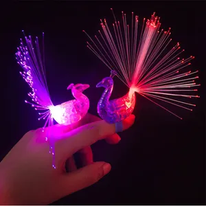 Close-up of vibrant peacock LED fiber optic finger rings glowing brightly in the dark