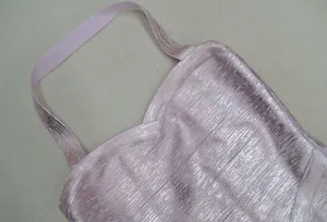 Vue détaillée de la texture métallique rose luxueuse sur la mini robe bandage sexy