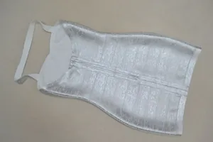 Gros plan sur la texture bandage métallique argentée de cette robe dos nu pour femme