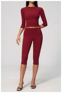 Detail showing dark red high-waisted yoga capri pants and matching long sleeve crop top