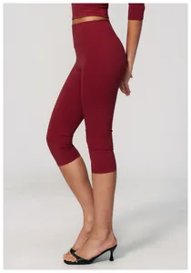 Close-up side view of high-waisted burgundy yoga capris showing a slim fit