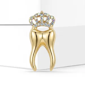 Close-up of creative gold tooth brooch featuring a sparkling rhinestone crown pin