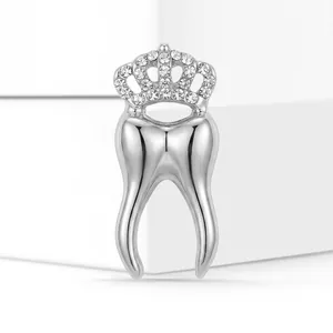Close-up of a silver alloy tooth brooch featuring a sparkling rhinestone crown detail