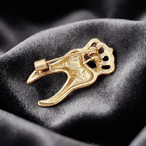 Detailed back view of a golden crown tooth shaped alloy brooch pin