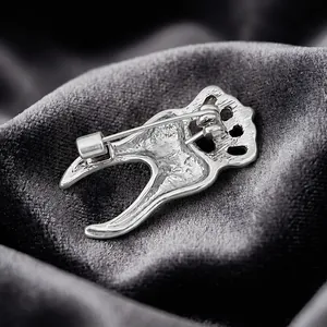 Creative silver-tone tooth brooch with a crown design and safety pin back for outfits