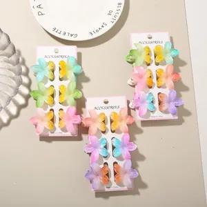 Detail view of multiple colorful gradient plumeria flower hair claw clips on display cards
