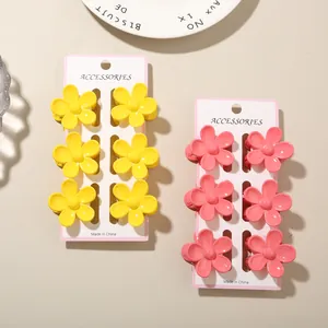 Detailed view of colorful flower-shaped hair claw clips in yellow and pink tones