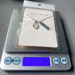 Macro view of stainless steel faith necklace on digital scale weighing 7.5 grams