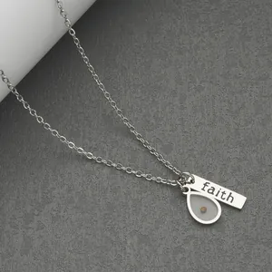 Close-up of stainless steel necklace with faith bar and mustard seed pendant