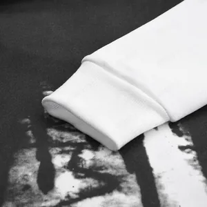 Close-up detail of white ribbed cuff on a black hoodie with splash ink print design