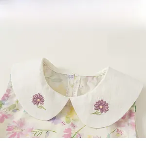Détail de robe à fleurs pour filles avec col Claudine brodé et tissu d'été léger