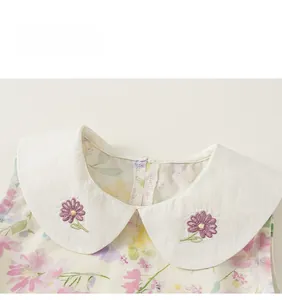 Détail d'une robe d'été à fleurs pour fille avec col Claudine brodé de fleurs mauves