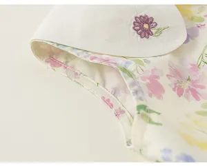 Détail d'une robe d'été fleurie pour fille avec col pétale blanc brodé à la main