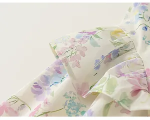 Gros plan sur l'imprimé floral français et les volants d'une robe d'été pour fille