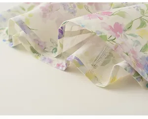 Gros plan sur les coutures de l'ourlet et l'imprimé floral d'une robe d'été pour fille