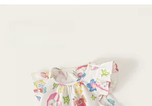 Détail de robe à fleurs pour filles avec imprimés cartoon et manches à volants.