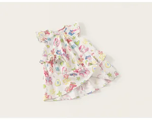 Vue détaillée des imprimés animaux et étoiles colorés sur une robe en coton blanc pour filles