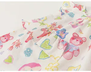 Gros plan sur l'imprimé ours en peluche et cœur coloré d'une robe à volants pour filles