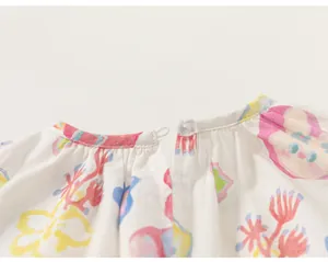 Détail en gros plan de la fermeture à bouton au dos d'une robe à fleurs pour petite fille