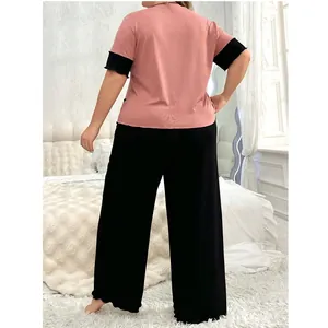 Vue arrière d'un ensemble de nuit grande taille avec haut rose et pantalon large noir