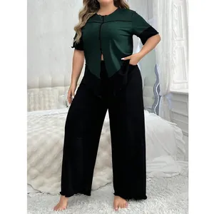 Détail d'un ensemble de détente grande taille avec haut vert foncé et pantalon noir ample