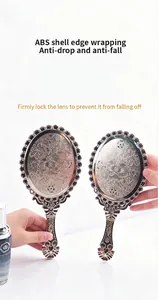 Close-up of vintage electroplated handheld mirror with intricate floral pattern.