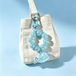 Translucent blue whale keychain featuring a sparkling beaded chain on a white bag