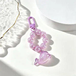 Detailed macro view of translucent purple whale keychain with sparkling beaded chain