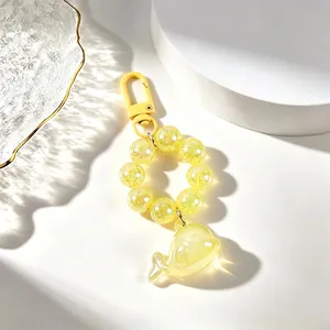 Close-up of yellow translucent whale keychain with sparkling beaded chain accessory