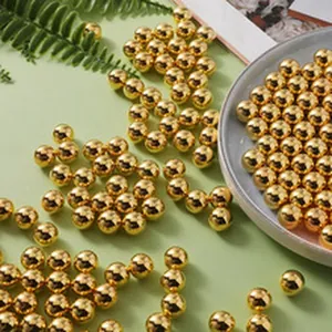 Close-up of shiny golden ABS round beads for DIY necklace and bracelet crafting projects