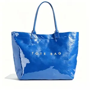 Detail view of a minimalist blue tote bag with a high-gloss crinkled texture