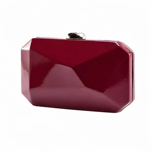 Close-up of wine red geometric evening clutch bag with elegant golden heart clasp