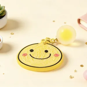 Detailed shot of a yellow smiley face acrylic keychain with a soft glowing orb detail